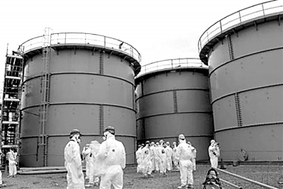 3月1日，一群日本記者在福島第一核電站內的污水儲藏罐前采訪。日益增多的核污水是當前事故搶修工作面臨的主要難題之一。資料圖片
