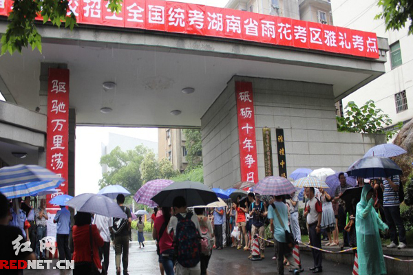 高考學子冒雨進入考場。