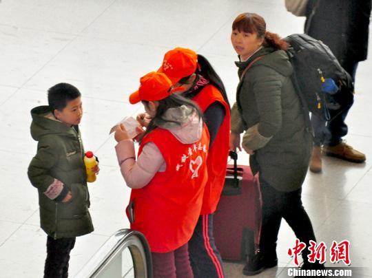 鐵路青年志愿者為攜帶兒童出行的旅客提供咨詢解答?！钦鳌z